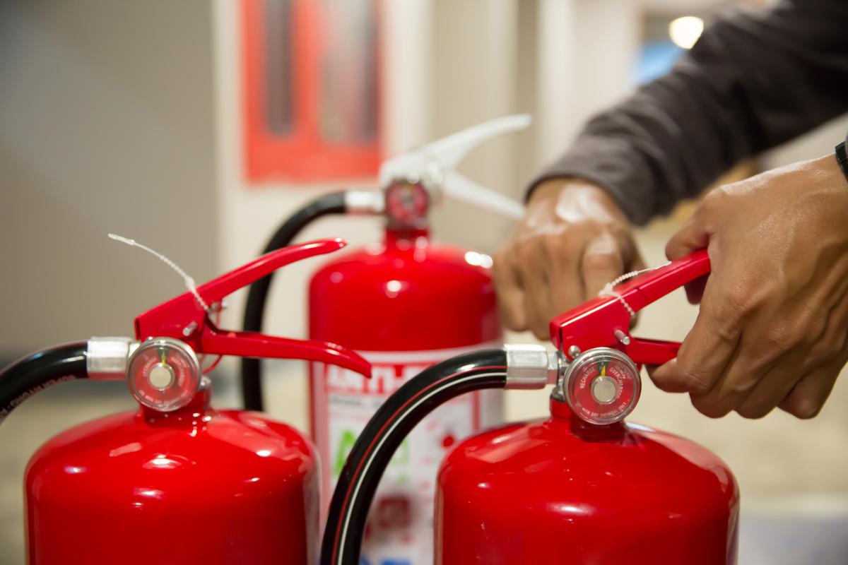 Engineers performing safety procedures on fire extinguishers